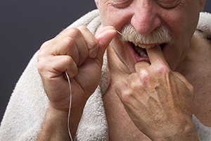 Hombre usando hilo dental.